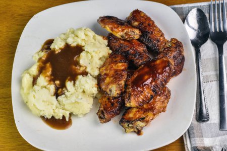 barbecue chicken wings served with mashpotatoes and gravy,