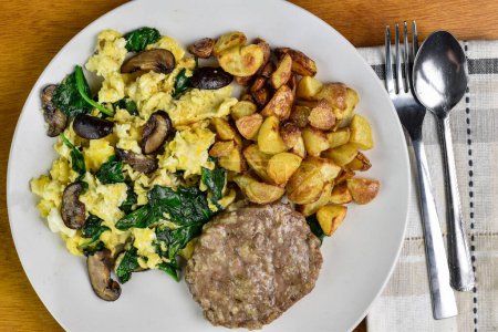 scramble eggs mixed with spinach and  mushrooms served with  home fries and sausage patty