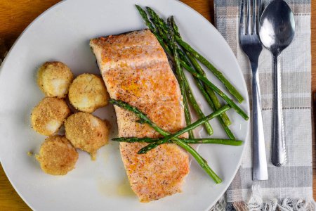 baked salmon  served with  scallops and sauteed asparagus