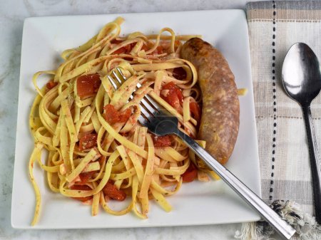 fettuccine  with diced tomatoes  and italian sausage.