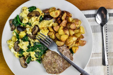 scramble eggs mixed with spinach and  mushrooms served with  home fries and sausage patty