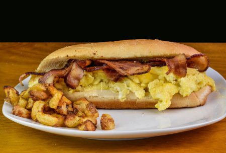 petit déjeuner sandwich aux ?ufs brouillés et bacon servi avec des frites maison