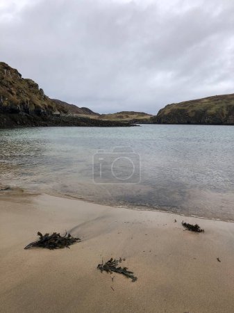 Foto de Una bahía de arena y algas marinas con el paisaje más amplio de la Isla de Lewis en abril, cerca de Dun Carloway, Hébridas Exteriores, Escocia, Reino Unido - Imagen libre de derechos