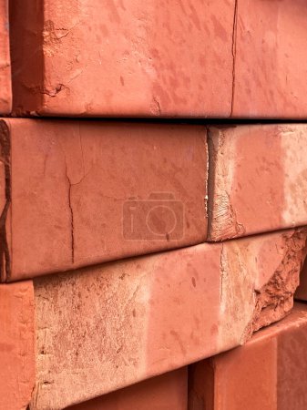 Detailed view of stacked red bricks with visible textures and imperfections