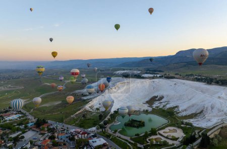Denizli, Turkey, May 1, 2023: Hot air balloons and Natural travertine pools at sunrise in Pamukkale, 