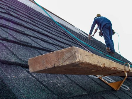 Photo for Support bracket and foot support on shingle roof installation. High quality photo - Royalty Free Image