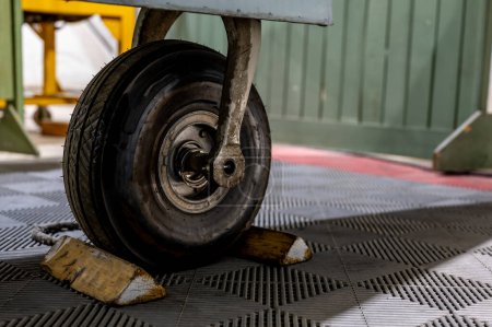 Téléchargez les photos : Chocs de roue à l'avant d'un aéronef stationné pour immobiliser le pneu. Photo de haute qualité - en image libre de droit
