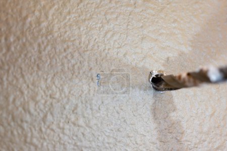 Foto de Enfoque selectivo en el punto de penetración de una broca haciendo un agujero piloto en paneles de yeso. Foto de alta calidad - Imagen libre de derechos