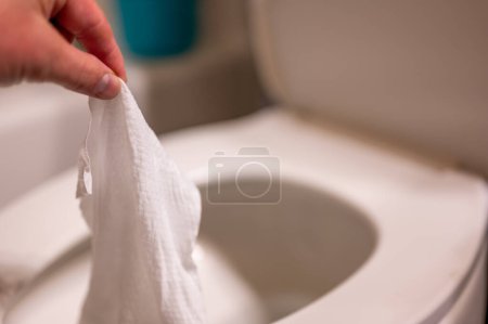 Photo for Disposable wipes being flushed down a toilet where they can cause clogging and problems with wastewater treatment. High quality photo - Royalty Free Image