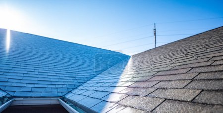 Téléchargez les photos : Ligne distincte de givre sur un toit en bardeaux que le soleil frappe la crête le matin - en image libre de droit