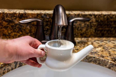 Photo for Improperly filling a neti pot with nonsterile tap water. High quality photo - Royalty Free Image