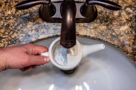 Photo for Improperly filling a neti pot with nonsterile tap water. High quality photo - Royalty Free Image