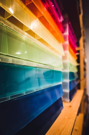 Téléchargez les photos : Rangées de bacs de rangement multicolores fourre-tout dans un espace de rayonnage de magasin de détail. Photo de haute qualité - en image libre de droit