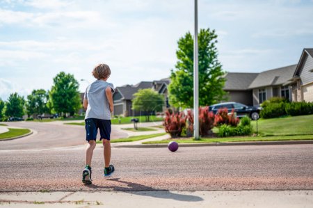 Chasing a ball that has crossed the street by rolling into a road. High quality photo