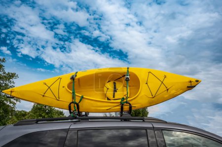 Techo montado en kayak en la parte superior de una furgoneta para su transporte. Foto de alta calidad