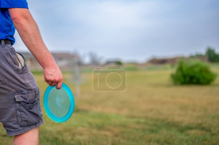 Téléchargez les photos : Homme adulte caucasien étudiant le vert avant de lancer un disque vers le but. Photo de haute qualité - en image libre de droit