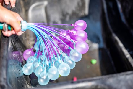Photo for Rapid filling self sealing water balloons being inflated with a hose. High quality photo - Royalty Free Image