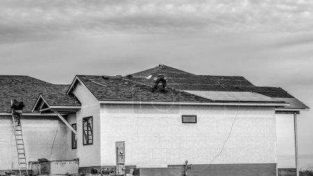 Photo for Shingle roof being installed on a two-story walkout new build residential construction house. . High quality photo - Royalty Free Image