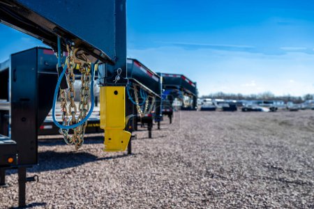 Photo for Selective focus on gooseneck trailer hitch with a row of flatbeds lined up. . High quality photo - Royalty Free Image