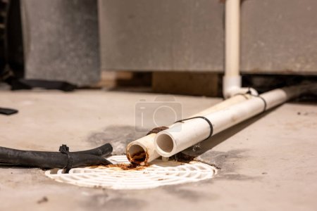 Selective focus on a residential house basement floor drain with furnace and water softener drain lines. High quality photo
