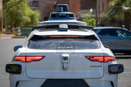 Téléchargez les photos : Phoenix, Arizona, USA - 3.23.2024 : Derrière une voiture autonome Waymo arrêtée à une intersection. Photo de haute qualité - en image libre de droit