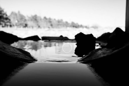 This black and white scene captures the contrast between water and rocks. The rocks are rugged and textured, while the water flows gracefully around them in a rocky stream.