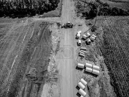 High angle view of a road construction project cutting through an agricultural district of farm fields. High quality photo