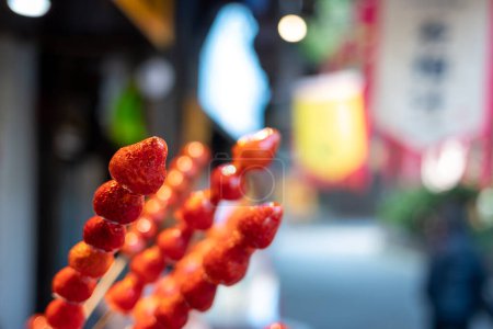 Photo for Tanghulu traditional Chinese hard caramel coated strawberry skewers close-up also called bing tanghulu candied hawthorn sticks - Royalty Free Image