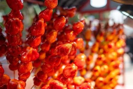 Photo for Tanghulu traditional Chinese hard caramel coated strawberry skewers close-up also called bing tanghulu candied hawthorn sticks - Royalty Free Image
