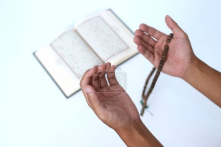 Gros plan des mains ouvrant les paumes en prière après avoir récité le Coran pendant le Ramadan sur fond blanc