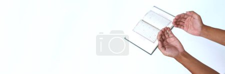 Photo for Close-up of hands opening up palms in prayer with copy space after reciting the Quran during Ramadan on a white background - Royalty Free Image