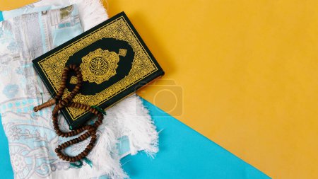 Der Heilige Koran mit Gebetsmatte und Tasbih auf blauem und gelbem Hintergrund
