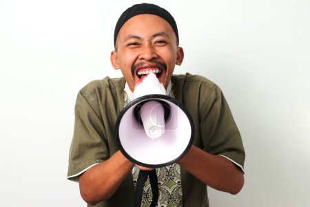 Excité homme musulman indonésien en koko et peci crie dans un mégaphone, annonçant suhoor (repas d'avant l'aube) pendant le Ramadan. Isolé sur fond blanc