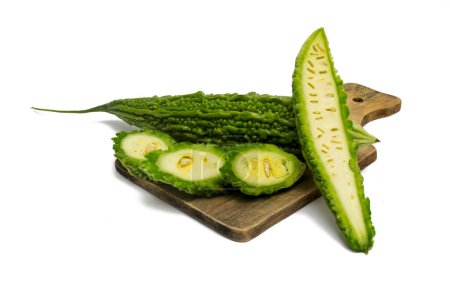Téléchargez les photos : Melon amer frais (Momordica charantia) entier et tranché. Isolé sur fond blanc. - en image libre de droit