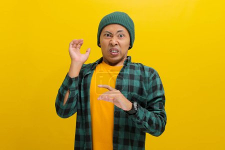 Ew. It's so gross. Displeased young Asian man, dressed in a beanie hat and casual shirt, wears a disgusted expression while visibly repulsed by something, standing against a yellow background