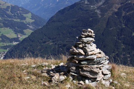 Photo for Large stone cairn in the mountains with a distant view of the green valley below - Royalty Free Image