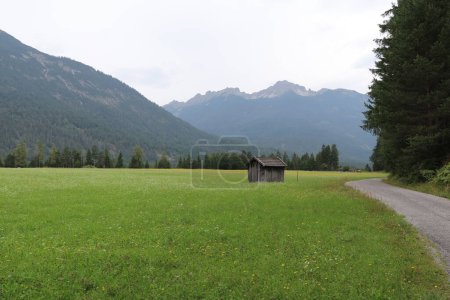 Photo for Little wooden mountain shed in a pastural meadow surrounded by mountains - Royalty Free Image