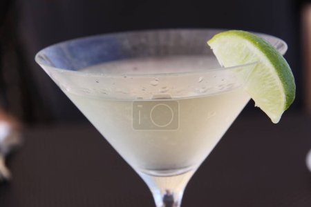Photo for Frosted cocktailglass with pale cocktail drink and lime wedge as garnish on the glass - Royalty Free Image