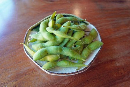 Edamame is Japanese dish and prepared of immature soybeans in the pod. The pods are boiled or steamed and may be served with salt.