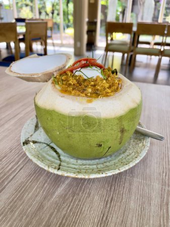 Marisco al curry picante estilo tailandés en coco fresco. Comida tailandesa. Hor Mok Talay el famoso marisco tailandés
