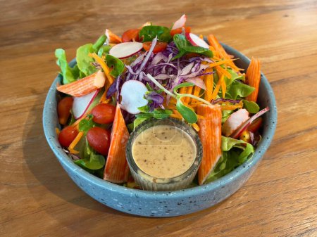 Téléchargez les photos : Salade de bâtonnets de crabe servie avec vinaigrette au sésame, mise au point sélective - en image libre de droit