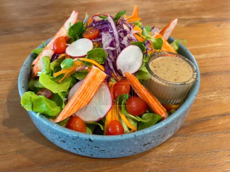Téléchargez les photos : Salade de bâtonnets de crabe servie avec vinaigrette au sésame, mise au point sélective - en image libre de droit