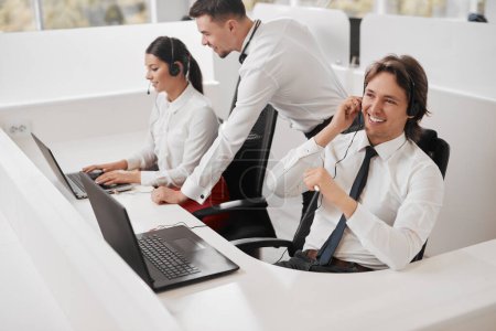 Téléchargez les photos : Angle élevé de collègues masculins et féminins passer des appels et utiliser un ordinateur portable tout en travaillant dans le bureau du département des ventes ensemble - en image libre de droit