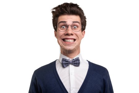 Téléchargez les photos : Goofy jeune homme en vêtements décontractés intelligents et lunettes en regardant la caméra avec un sourire fou sur fond blanc - en image libre de droit