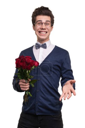 Photo for Cheerful young man in smart casual clothes and glasses with red roses smiling and looking at camera during data against white background - Royalty Free Image