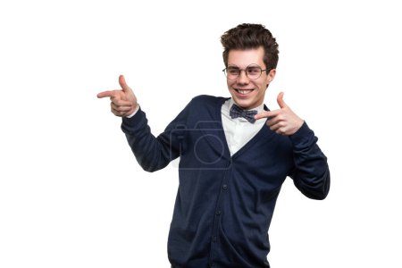 Photo for Young male student in smart casual clothes and glasses smiling and pointing away against white background - Royalty Free Image