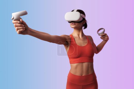 Photo for Side view of anonymous female in VR goggles aiming with virtual bow, while playing video game and experiencing virtual reality against pink and blue background - Royalty Free Image