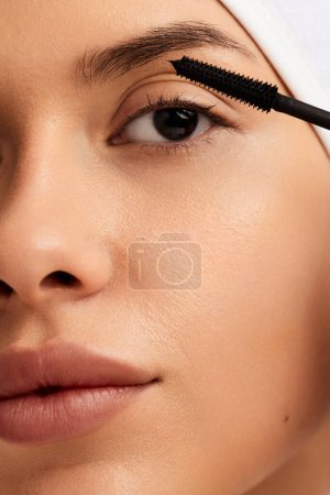 Photo for Closeup face of young woman with applying mascara on eyelashes, macro crop shot - Royalty Free Image