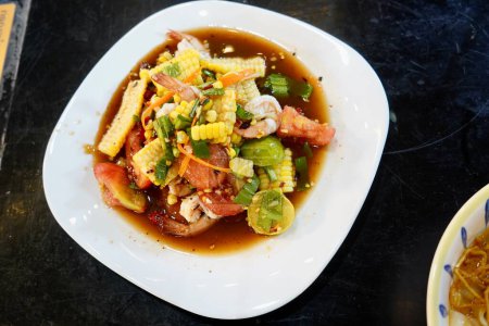 Téléchargez les photos : Crevettes maïs salade épicée délicieux plat sur la nourriture de rue Thaïlande. - en image libre de droit