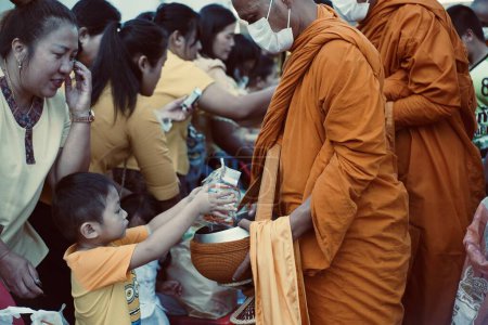 Photo for Give food offerings to a Buddhist monk On the occasion of Thai Father's Day , 5 December 2023 , Buriram Thailand. - Royalty Free Image